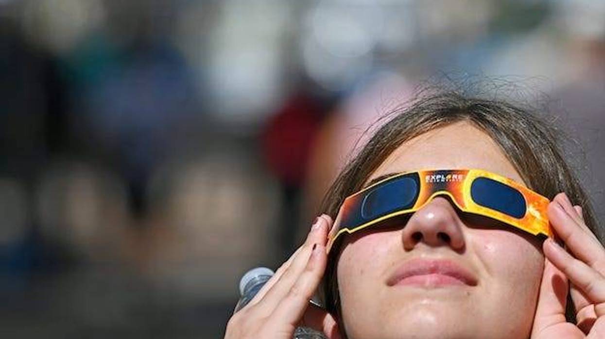 13-year-old Layla Strohm gets a quick glance safely with solar glasses of the awe-inspiring celestial event in Bradenton, Florida; solar eclipse
