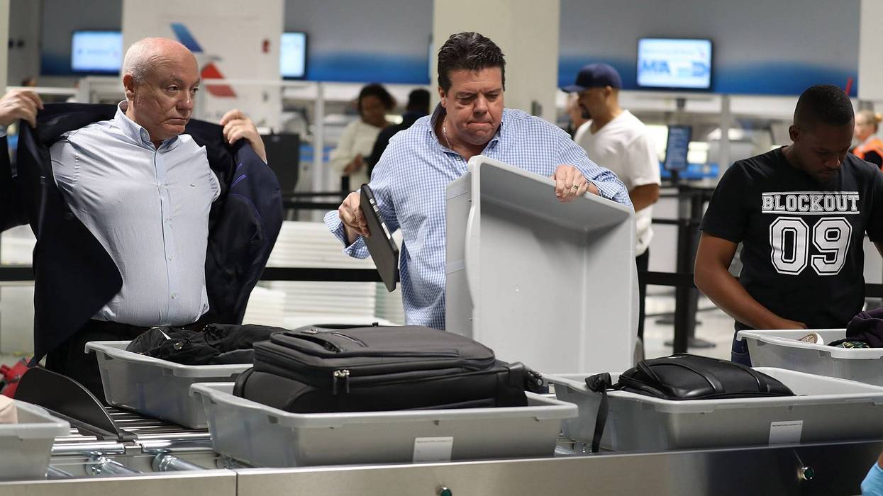 2 men at a TSA checkpoint at an airport
