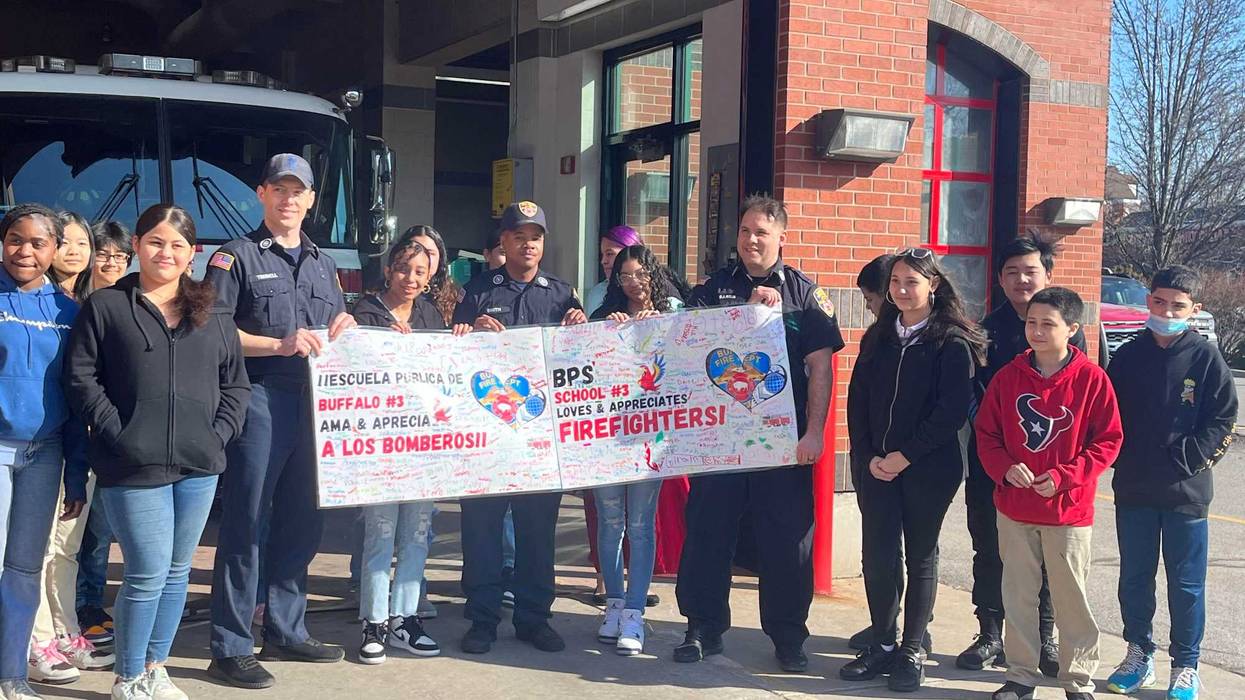 7th graders of Buffalo's School 3, the D'Youville Porter Campus School, standing with Buffalo firefighters of Engine No. 2.