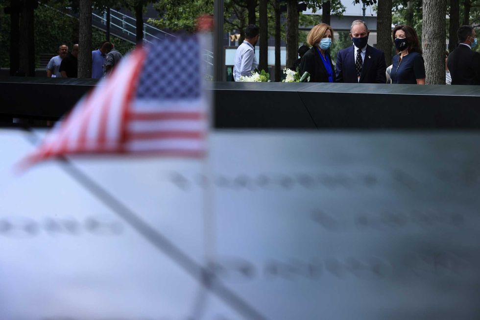 9/11 Memorial & Museum president Alice Greenwald (L) talks with Gov. Kathy Hochul (R) and former Mayor Mike Bloomberg after they laid flowers at the south memorial pool to commemorate the 20th anniversary of the September 11 terror attack on September 08, 2021