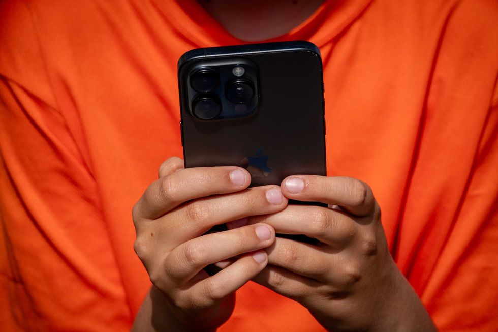 A 12-year-old boy looks at a iPhone screen