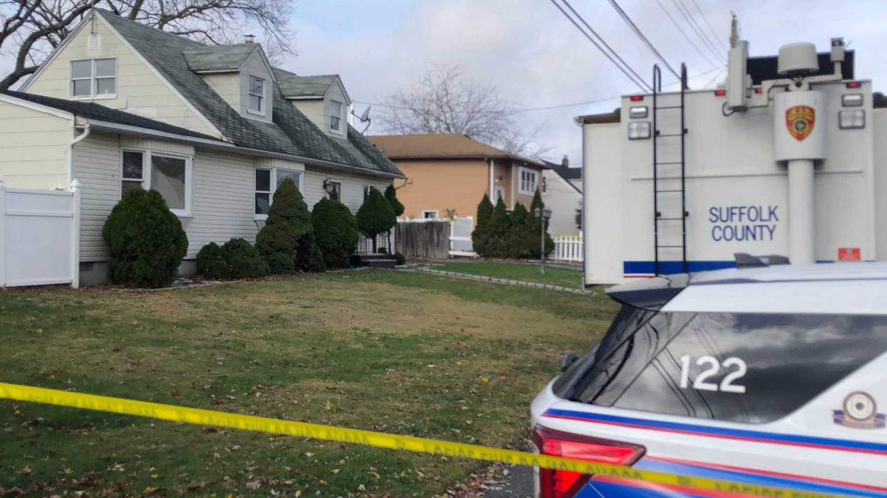 A 54-year-old woman was found dead inside a kitchen at this two-family home in Deer Park on Wednesday morning. Her 33-year-old son was "covered in blood" when he was arrested at the scene