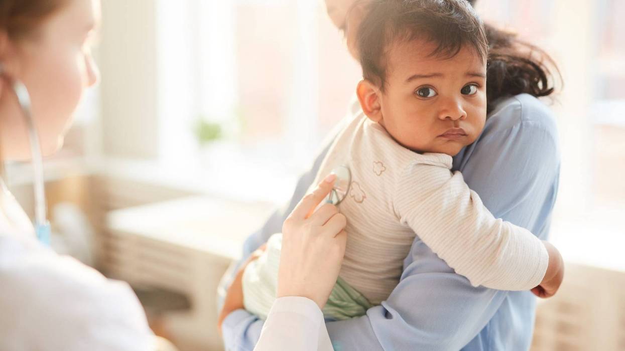 A baby being examined by a medical professional.
