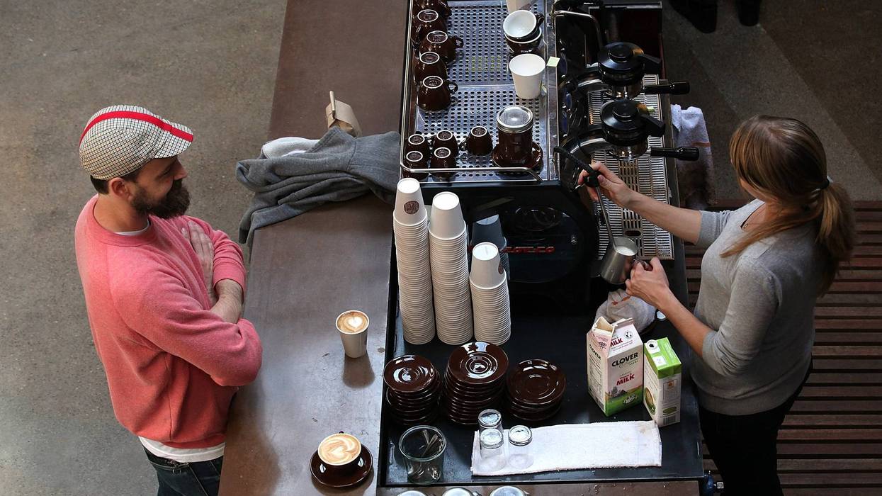 A barista (R) at Sightglass Coffee makes a coffee drink for a customer on August 26, 2011 in San Francisco, California.