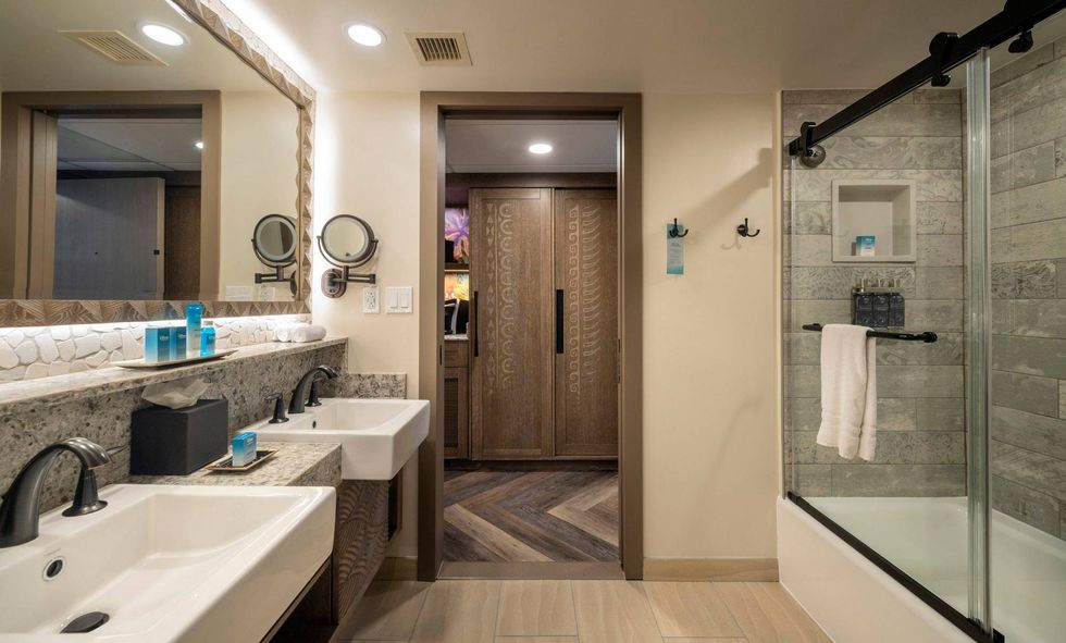 A bathroom in the reimagined guest rooms inside Disney’s Polynesian Village Resort at Walt Disney World Resort in Lake Buena Vista, Fla., takes inspiration from the sandy ocean floor for the bathroom tiles and vanity’s carved details.