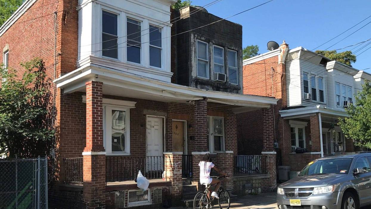 A bicyclist passes a blighted Camden block
