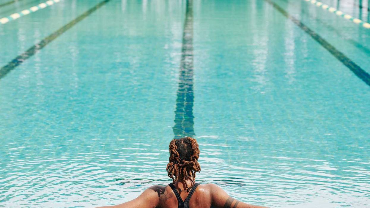 A Black woman in a pool without a swim cap.