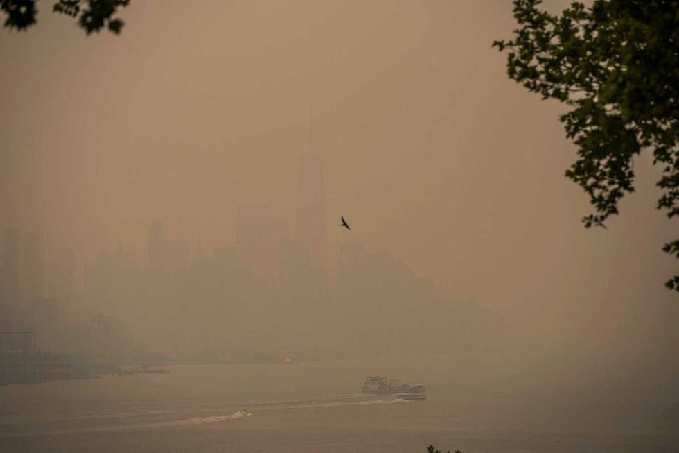 A boat navigates the Hudson River as the New York City skyline is covered with haze and smoke from Canada wildfires on June 7, 2023, in Weehawken, New Jersey