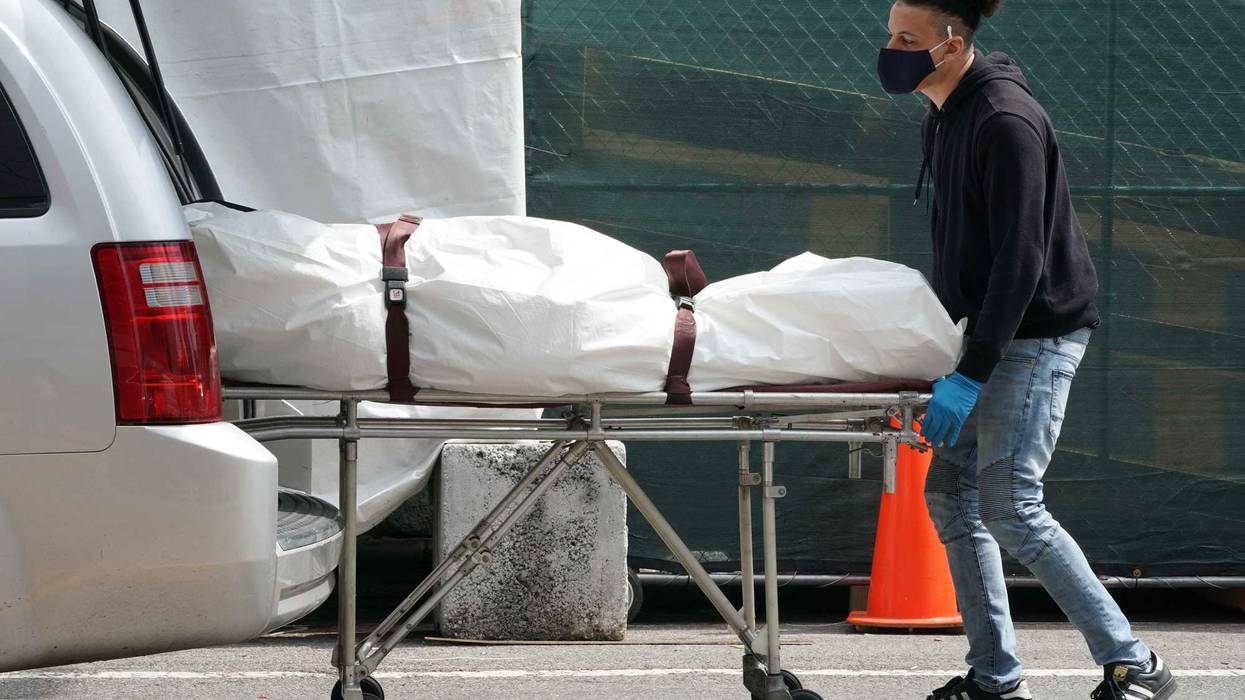 A body is moved from a refrigeration truck serving as a temporary morgue to a vehicle at the Brooklyn Hospital Center, in the Borough of Brooklyn on April 8, 2020 in New York.