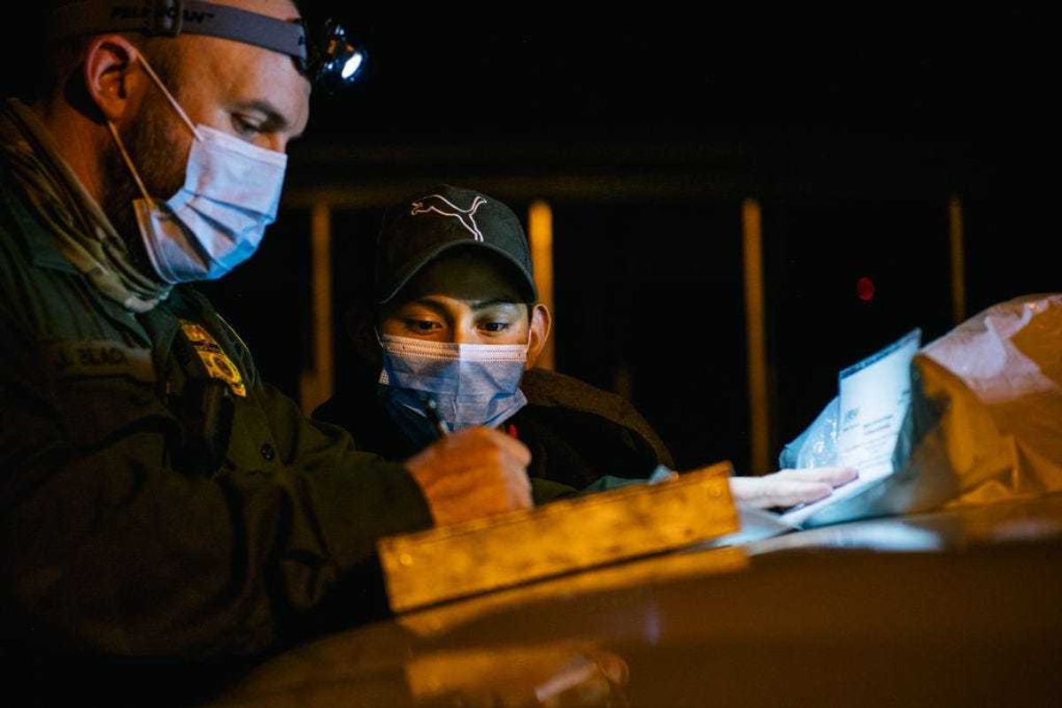 A border patrol officer begins processing a young boy after he crossed the Rio Grande into the U.S. on November 17, 2021 in La Joya, Texas.