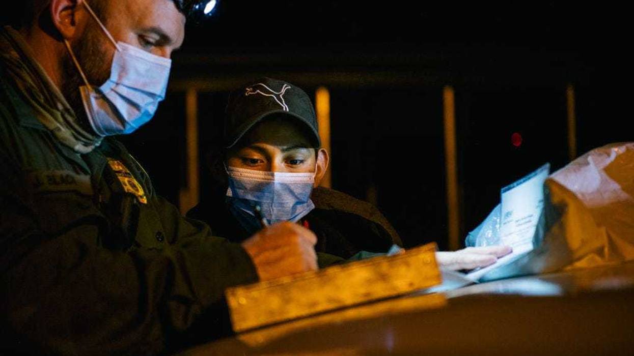 A border patrol officer begins processing a young boy after he crossed the Rio Grande into the U.S. on November 17, 2021 in La Joya, Texas.