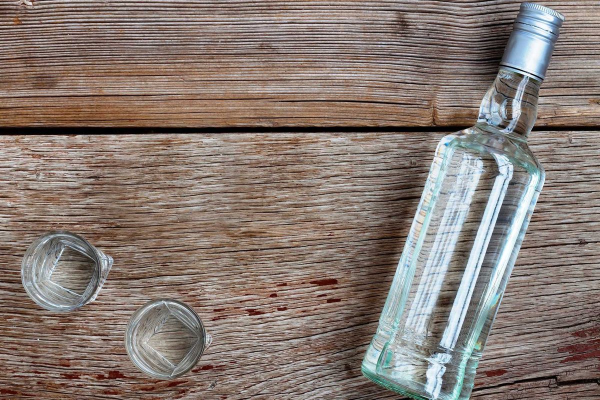 A bottle of vodka and two shot glasses.