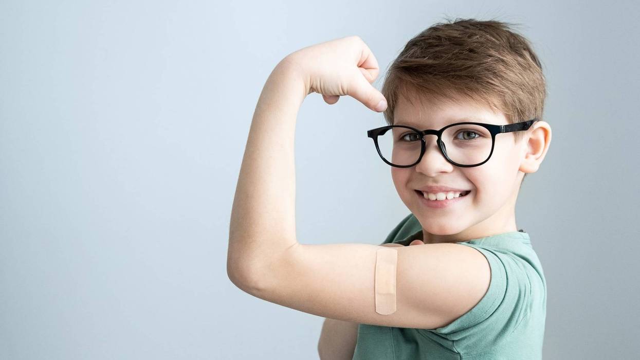 A boy shows off his bandaid after getting the COVID-19 Vaccine