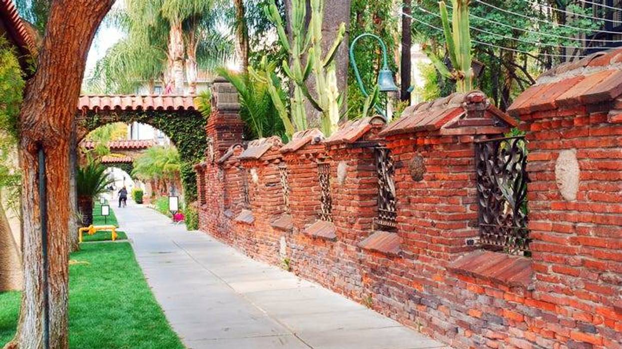 A brick wall, built in the Mission stye surrounds the Mission Inn, a historic hotel in Riverside California