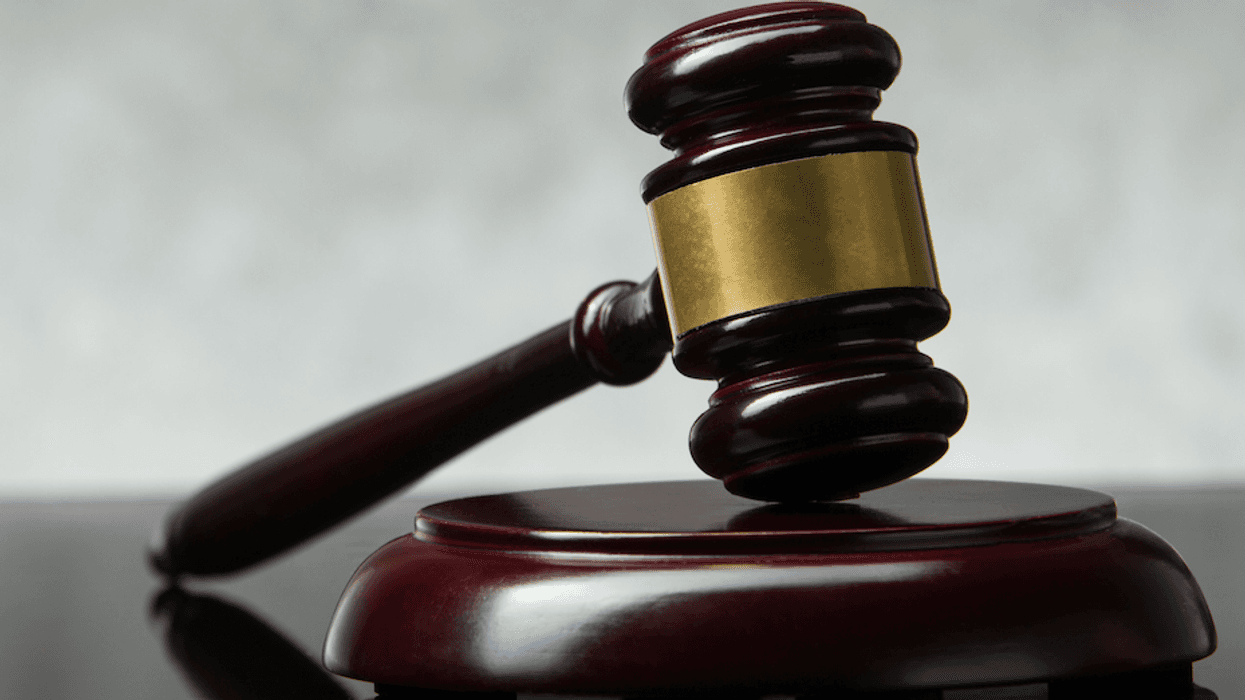 A brown, polished gavel set against a gray background.