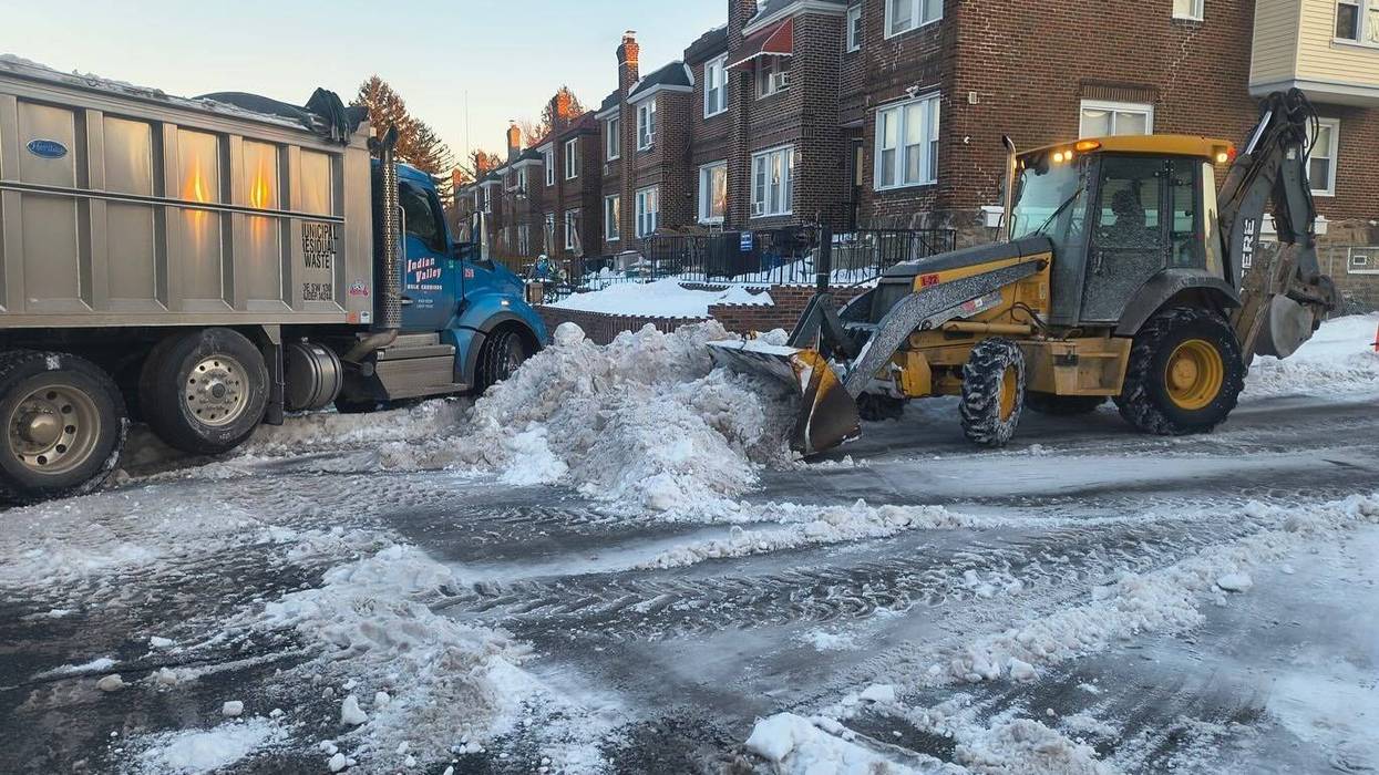A bulldozer and truck involved in snow removal.