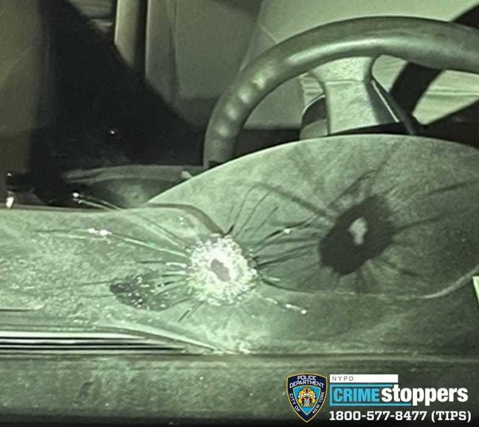 A bullet entered the windshield of an unmarked patrol car and struck an NYPD officer in his upper left arm, police said