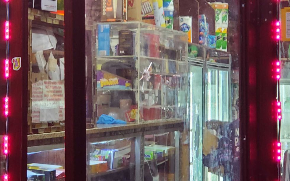 A bullet hole is seen in the glass door of the deli on Tuesday morning