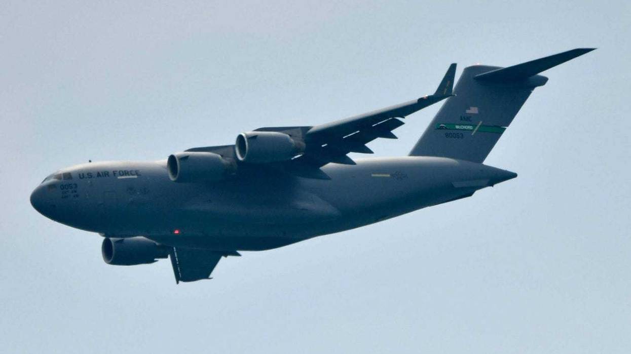 A C-17 cargo plane flies over the crowd at an air show.