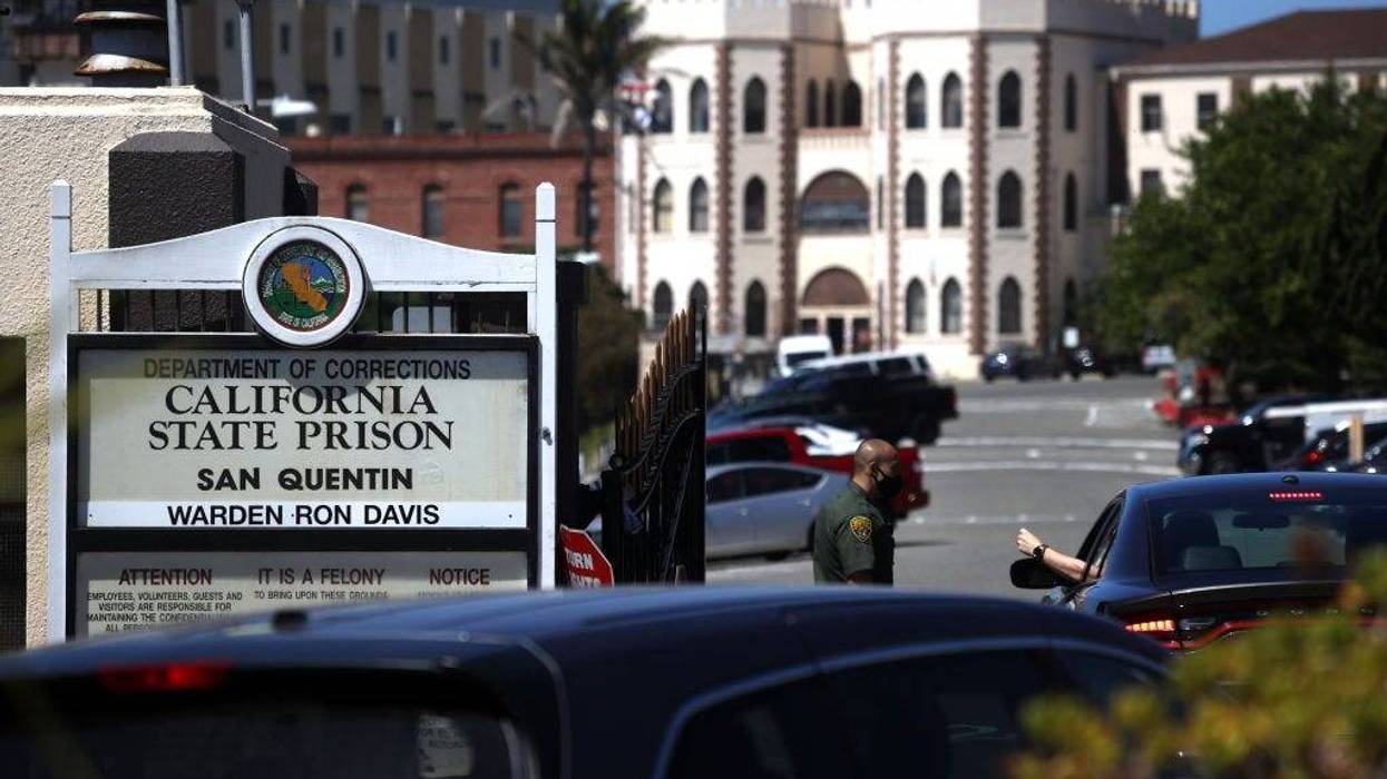 A California Department of Corrections and Rehabilitation (CDCR) officer wears a protective mask as he stands guard at the front gate of San Quentin State Prison on June 29, 2020 in San Quentin, California.