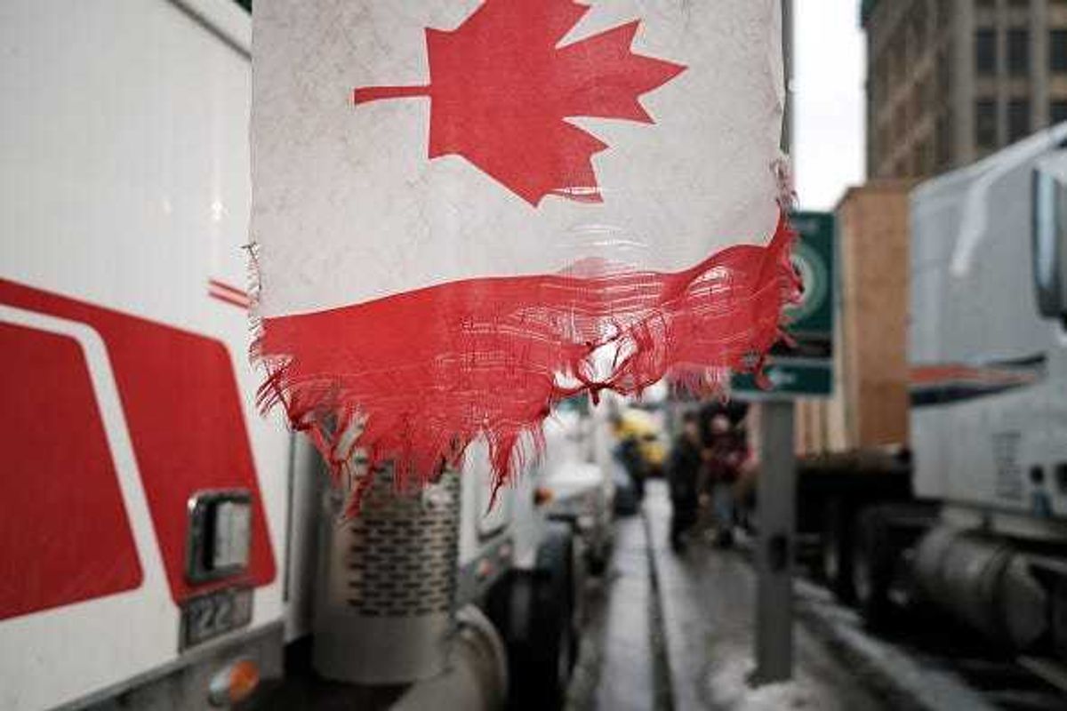A Canadian flag hangs from a truck.