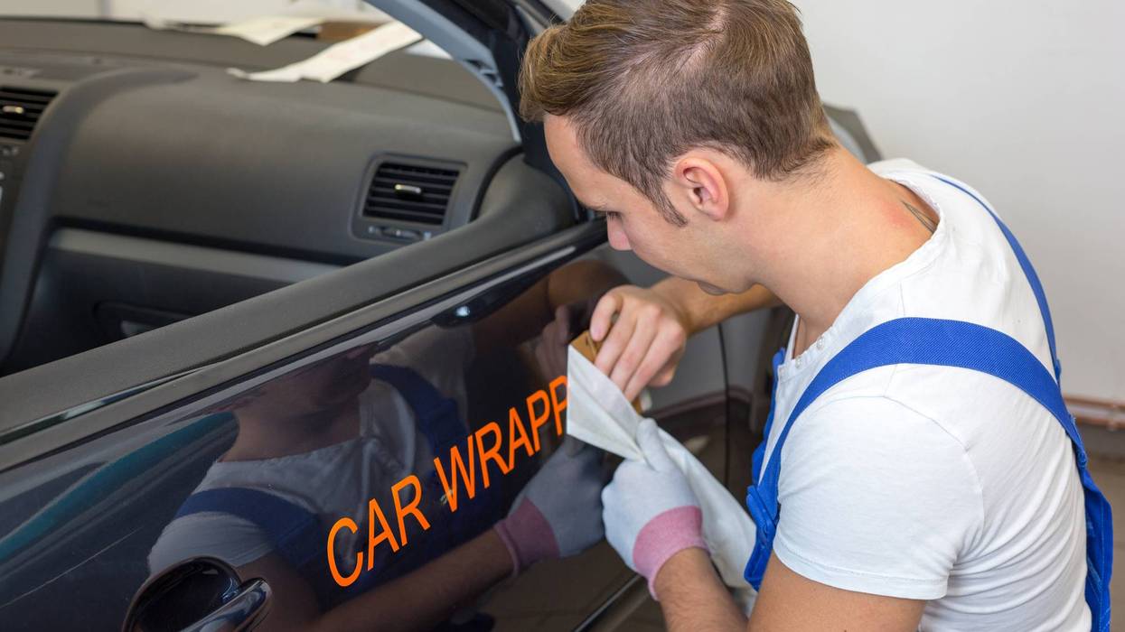 A car branding specialist applying a logo to a car