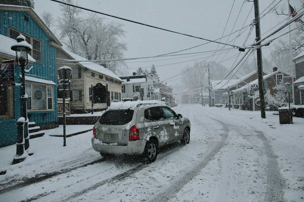 A car drives along Main Street as snow falls in Tappan, Rockland County, on February 10, 2024