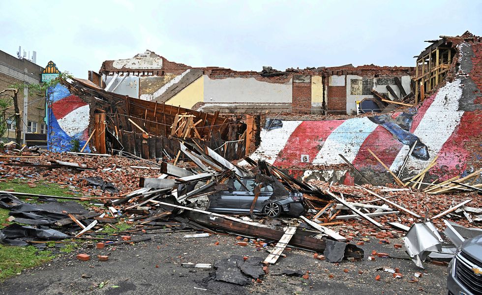 A car is crushed by the fallen building that hosted the Gansevoort mural that was struck by a tornado, in Rome, N.Y., Tuesday, July 16, 2024