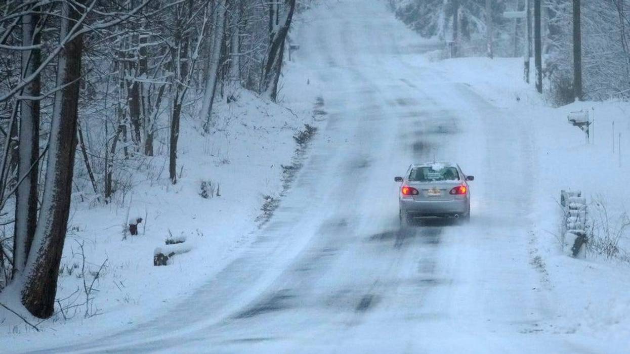 A car treks down a snow-covered road, Sunday, Jan. 7, 2024.