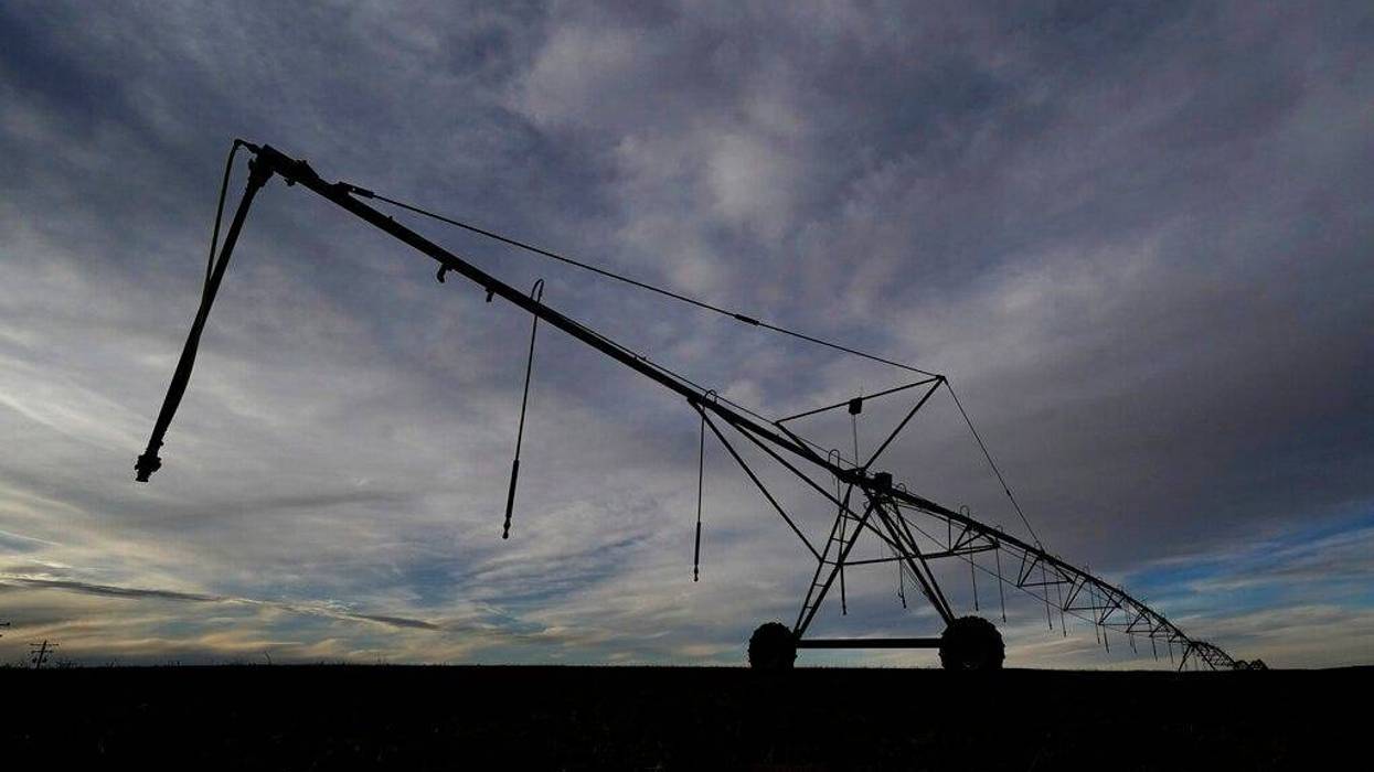 A center pivot irrigation sprinkler stretches across a field