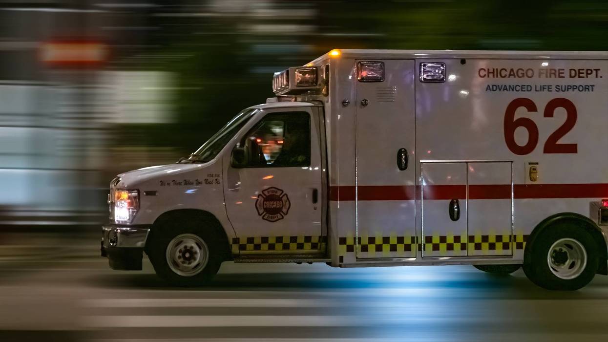 A Chicago Fire Department Advanced Life Support Ambulance (Unit 62) captured with motion blur as it speeds through an urban area at night.