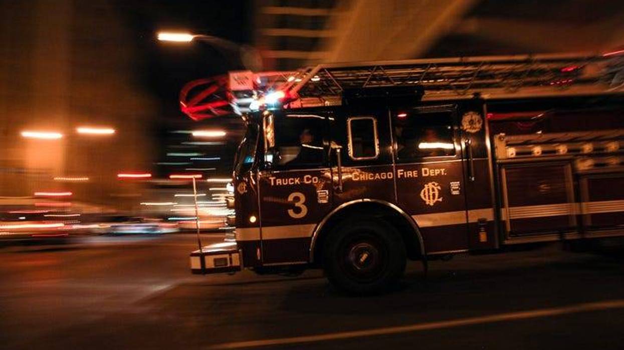 A Chicago Fire Department (CFD) squad vehicle rushes to an emergency call in a blurred pan shot.