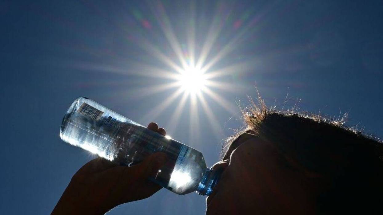 A child sips water from a bottle under a scorching sun on August 30, 2022, in Los Angeles.