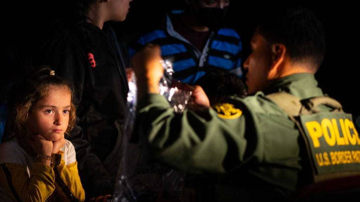 A child watches as a border patrol officer processes her family's belongings after they crossed the Rio Grande into the U.S. on May 05, 2022 in Roma, Texas. Texas Gov. Greg Abbott's "Operation Lone Star" directed approximately 10,000 members of the National Guard to assist law enforcement with patrol and border apprehensions. The operation is expected to receive another $500 million to further secure the southern border. Towns along the border continue making preparations as Title 42 is scheduled to end on May 23rd. (Photo by Brandon Bell/Getty Images)