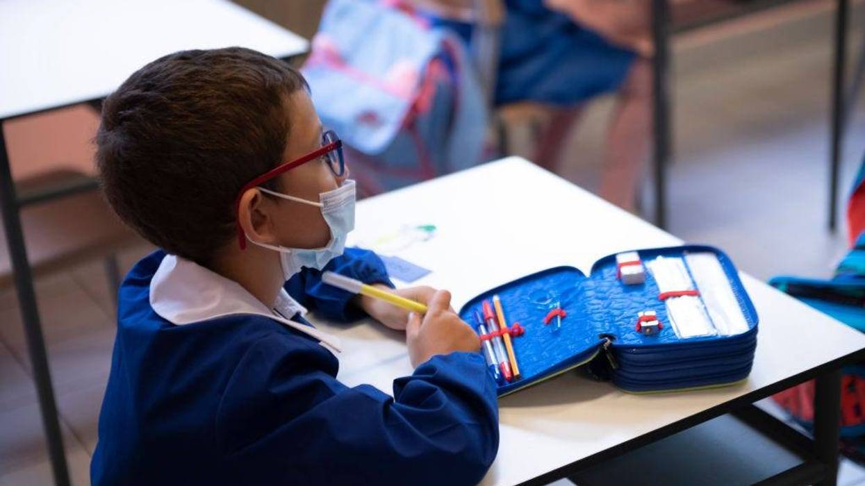 A child wears a protective mask inside an elementary school classroom.