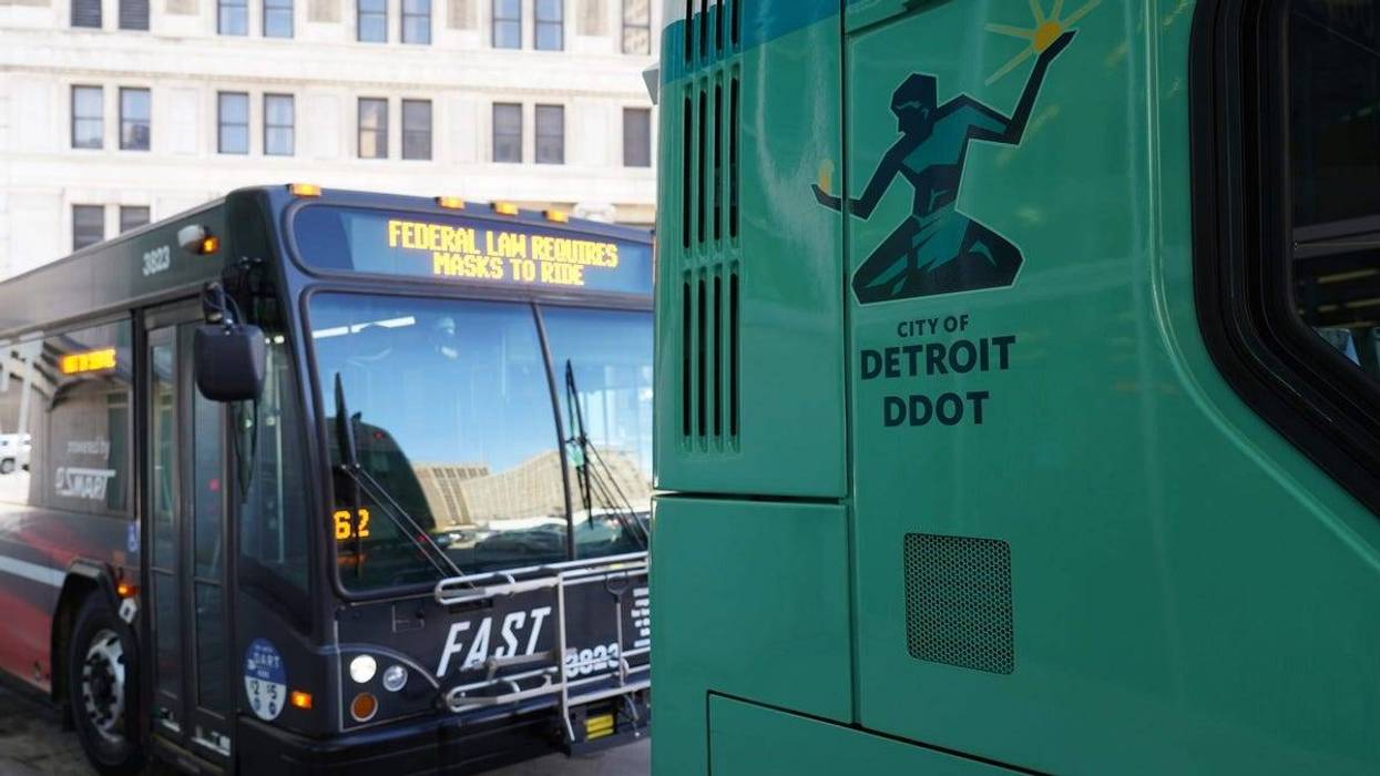 A City of Detroit DDOT bus and a Smart bus are parked at the Rosa Parks Transit Center in downtown Detroit