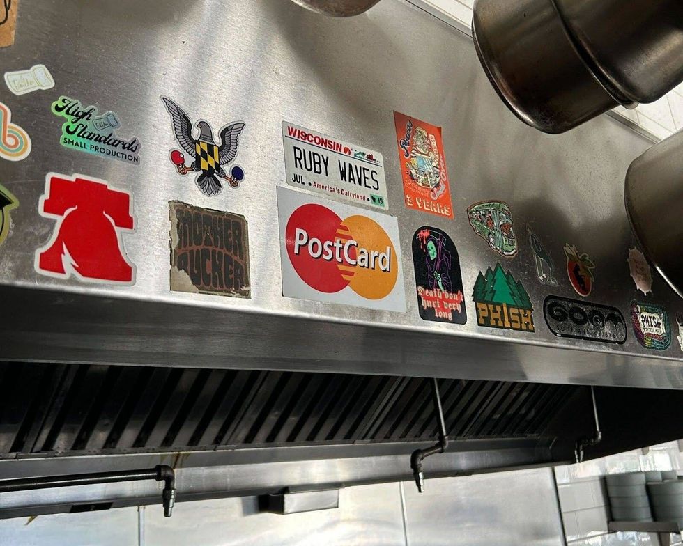 A collection of stickers that River Twice chef and co-owner Randy Rucker has affixed to the hood vent above his stove. He considers the restaurant