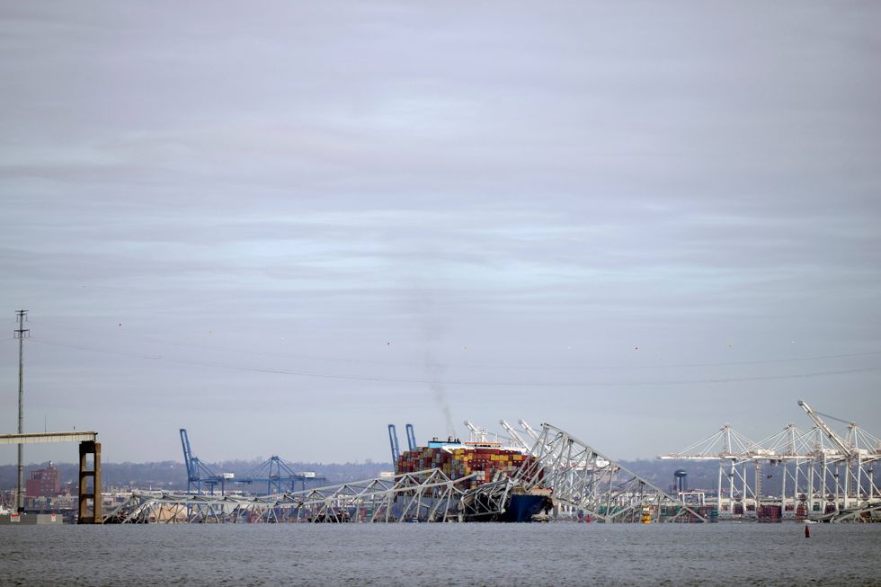 A container ship rests against the wreckage of the Francis Scott Key Bridge on Tuesday, March 26, 2024, as seen from Pasadena, Md. The container ship rammed into the major bridge in Baltimore early Tuesday, causing it to collapse in a matter of seconds and creating a terrifying scene as several vehicles plunged into the chilly river below.