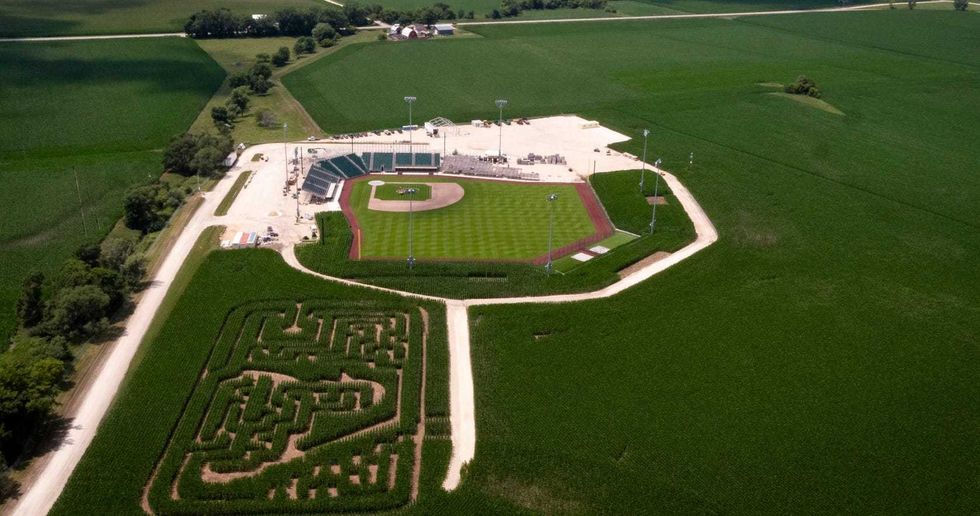 A corn maze made to look like the MLB logo sits between a new stadium (pictured) built on the "Field of Dreams" site and the iconic field carved into a cornfield.