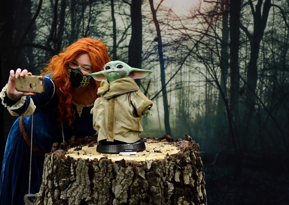 A cosplayer poses with Baby Yoda at 2021 Los Angeles Comic Con at Los Angeles Convention Center on December 03, 2021 in Los Angeles, California.