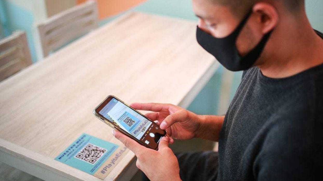 A costumer reads the QR code to display the digital menu at "Mariscos Mariola" restaurant on July 03, 2020 in Mexico City, Mexico.