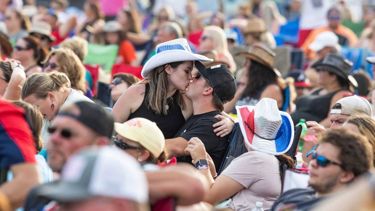 A couple kiss in the middle of a crowd during a three-day music festival in Panama City Beach called the Gulf Coast Jam.