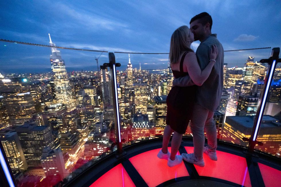 A couple shares a kiss above the city on Skylift at Top of the Rock Observation Deck, a new attraction at Rockefeller Center that elevates visitors nearly 900 feet above street level for unobstructed, 360-degree views, on Monday, Sept. 30, 2024, in New York.