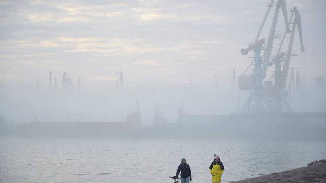 A couple walks on a beach near the port of Berdyansk on the Azov Sea on February 16, 2022 in Berdyansk, Ukraine.(Photo by Pierre Crom/Getty Images)