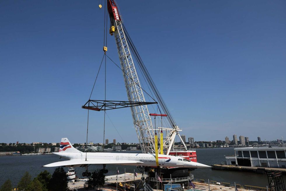A crane prepares to lift the Concorde into the air, clearing space below.