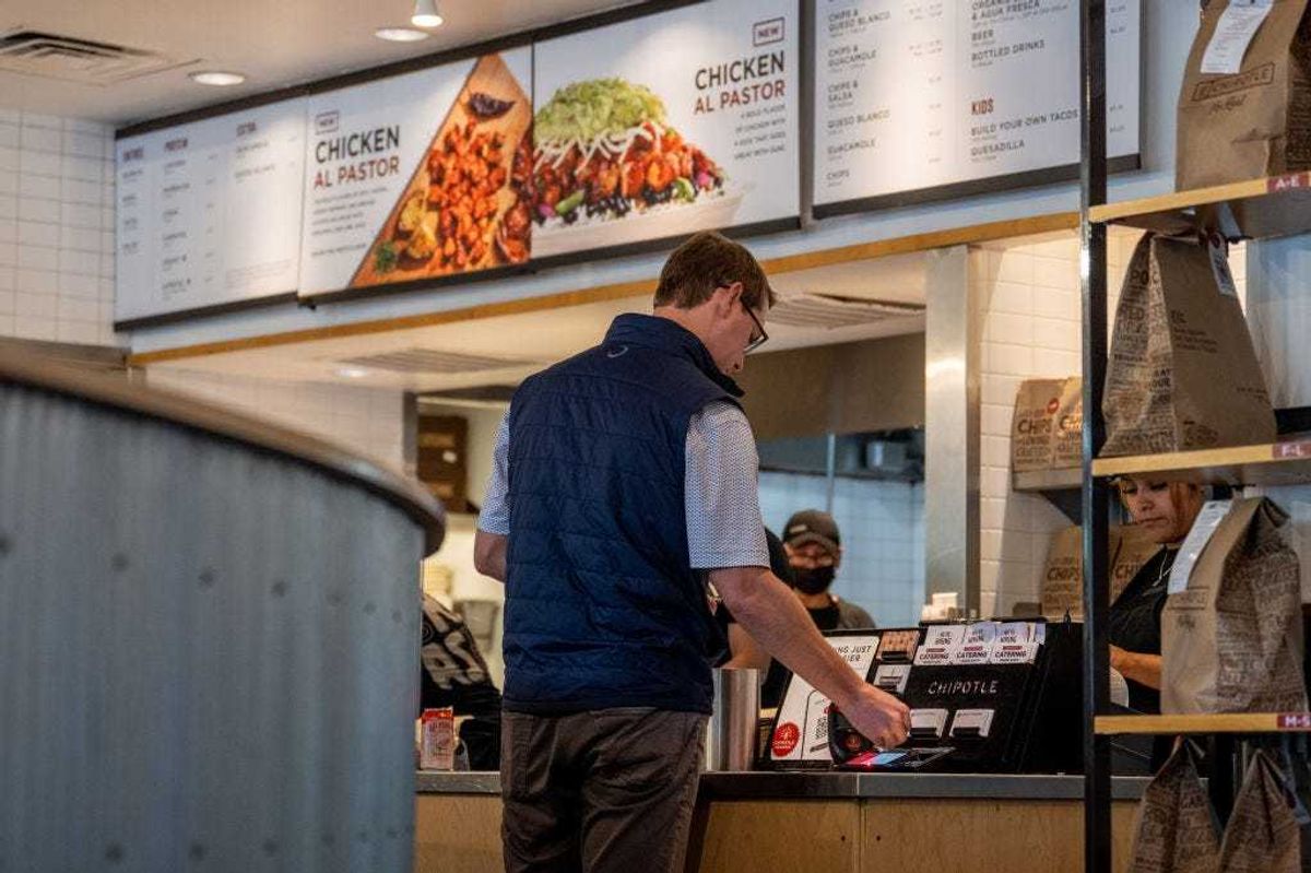 A customer pays for their food at a Chipotle Mexican Grill restaurant on April 26, 2023 in Austin, Texas.