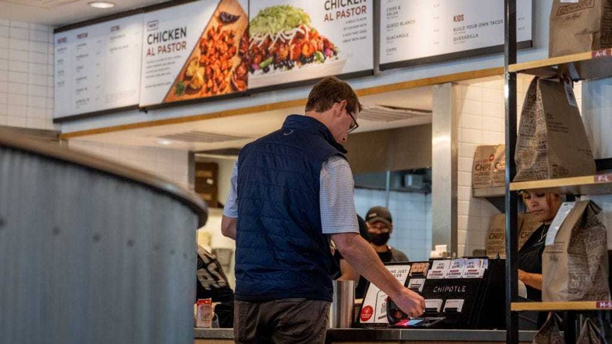 A customer pays for their food at a Chipotle Mexican Grill restaurant on April 26, 2023 in Austin, Texas.