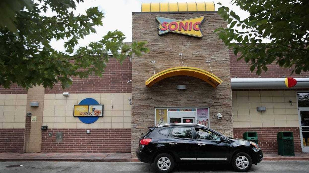 A customer picks up food at the drive-up window at a Sonic restaurant on September 25, 2018.