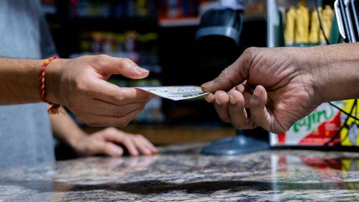 A customer purchases a Powerball lottery ticket at the Brew Market & Cafe on October 10, 2023 in Austin, Texas. The Powerball jackpot has grown to over $1.7 billion, making it the second largest jackpot in history. (Photo by Brandon Bell/Getty Images)
