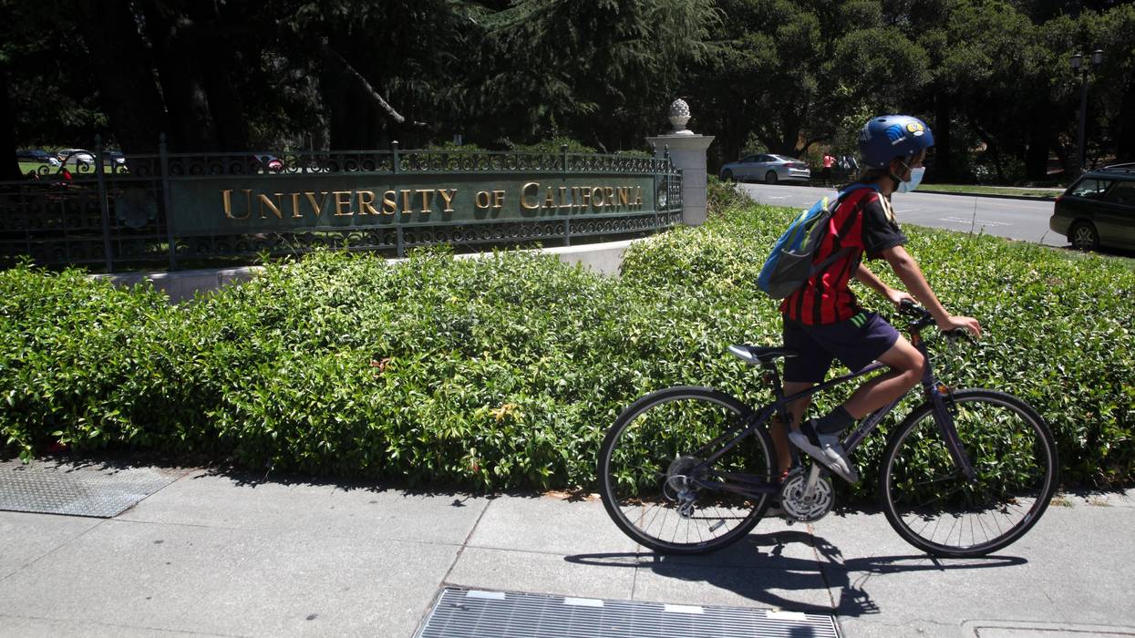 A cyclist rides by a sign in front of the U.C. Berkeley campus on July 22, 2020 in Berkeley, California